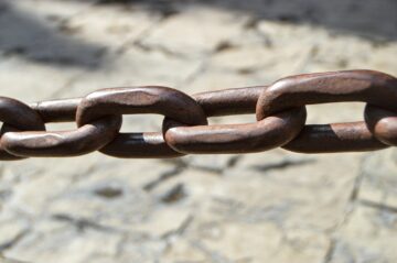 a close up of a metal chain on a stone surface